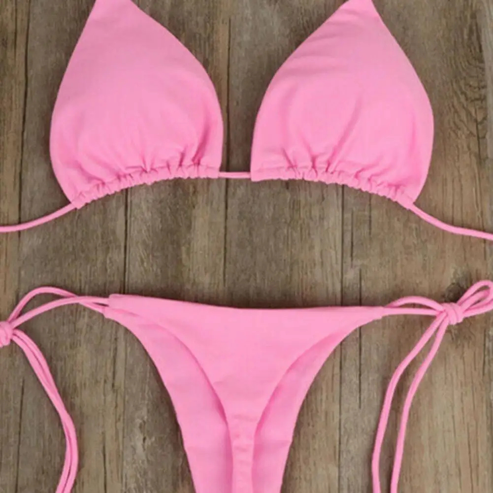 Maillot de bain femme 2 pièces de couleur rose posé sur une table 