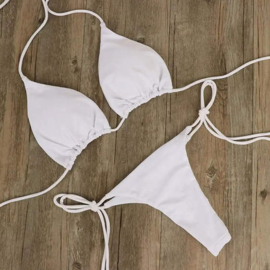 Maillot de bain 2 pièces blanc posé sur une table et sans motif 